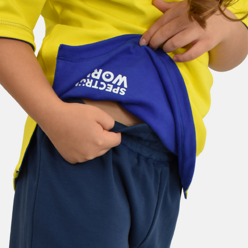 autistic child smiling while wearing tagless, reversible adaptive clothing made for sensory ease and dressing independence